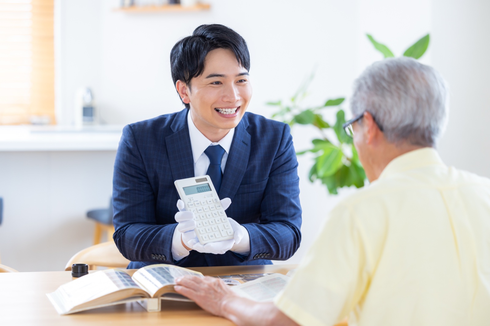 ご自宅でお客様に査定金額を説明するスタッフ